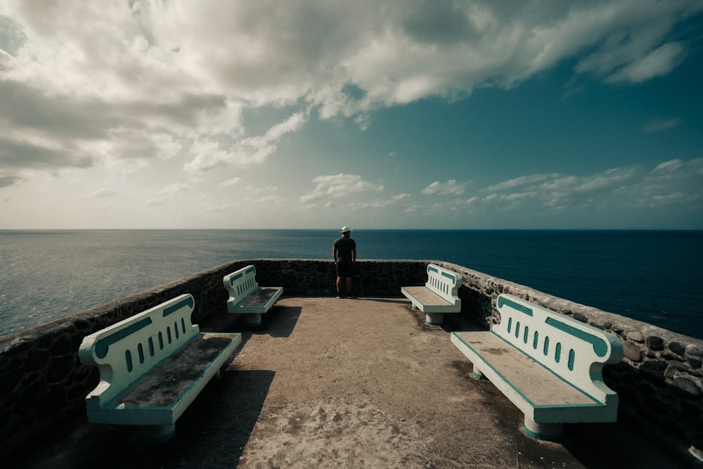 woman in black shirt standing on brown concrete dock during daytime