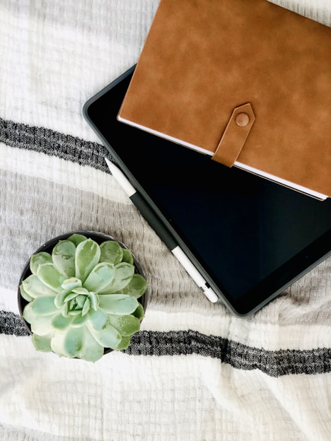 black tablet computer on white and black textile