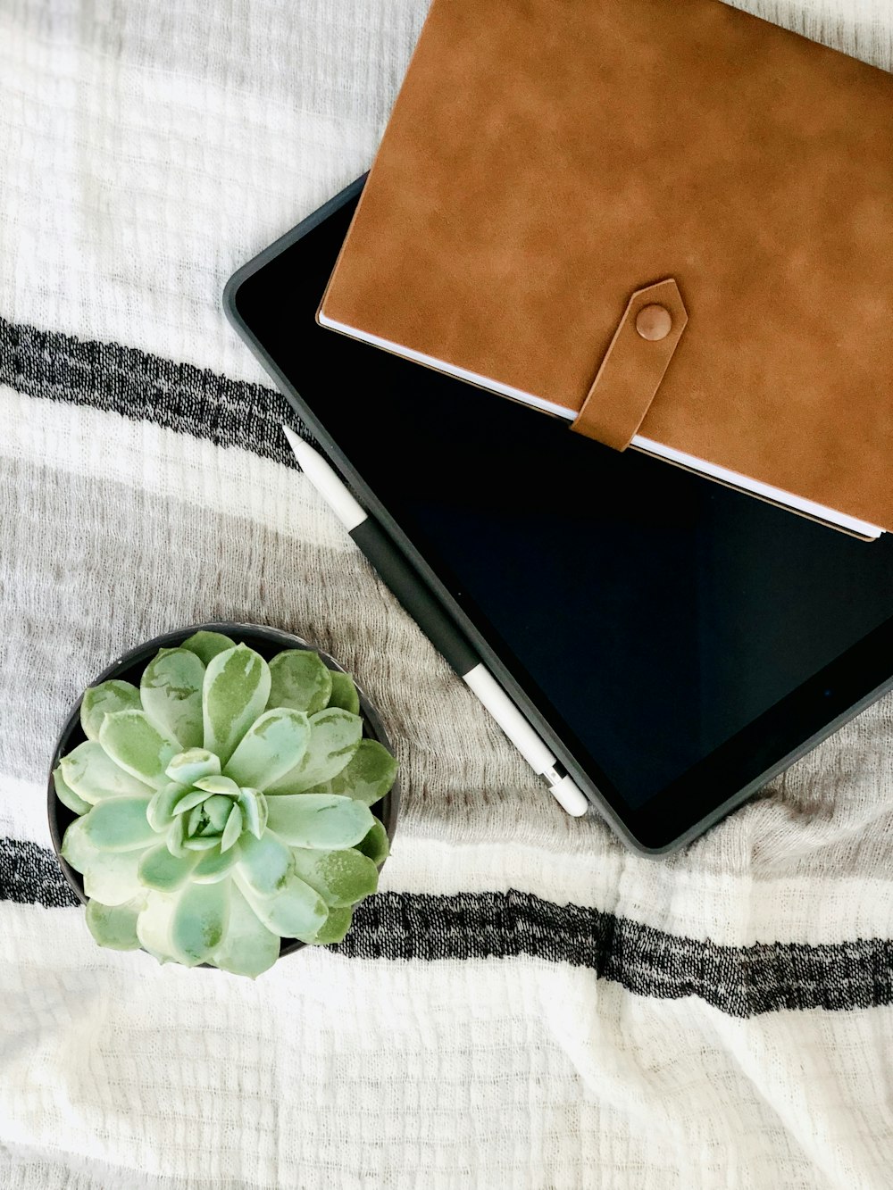 black tablet computer on white and black textile