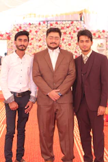 3 men in brown suit standing