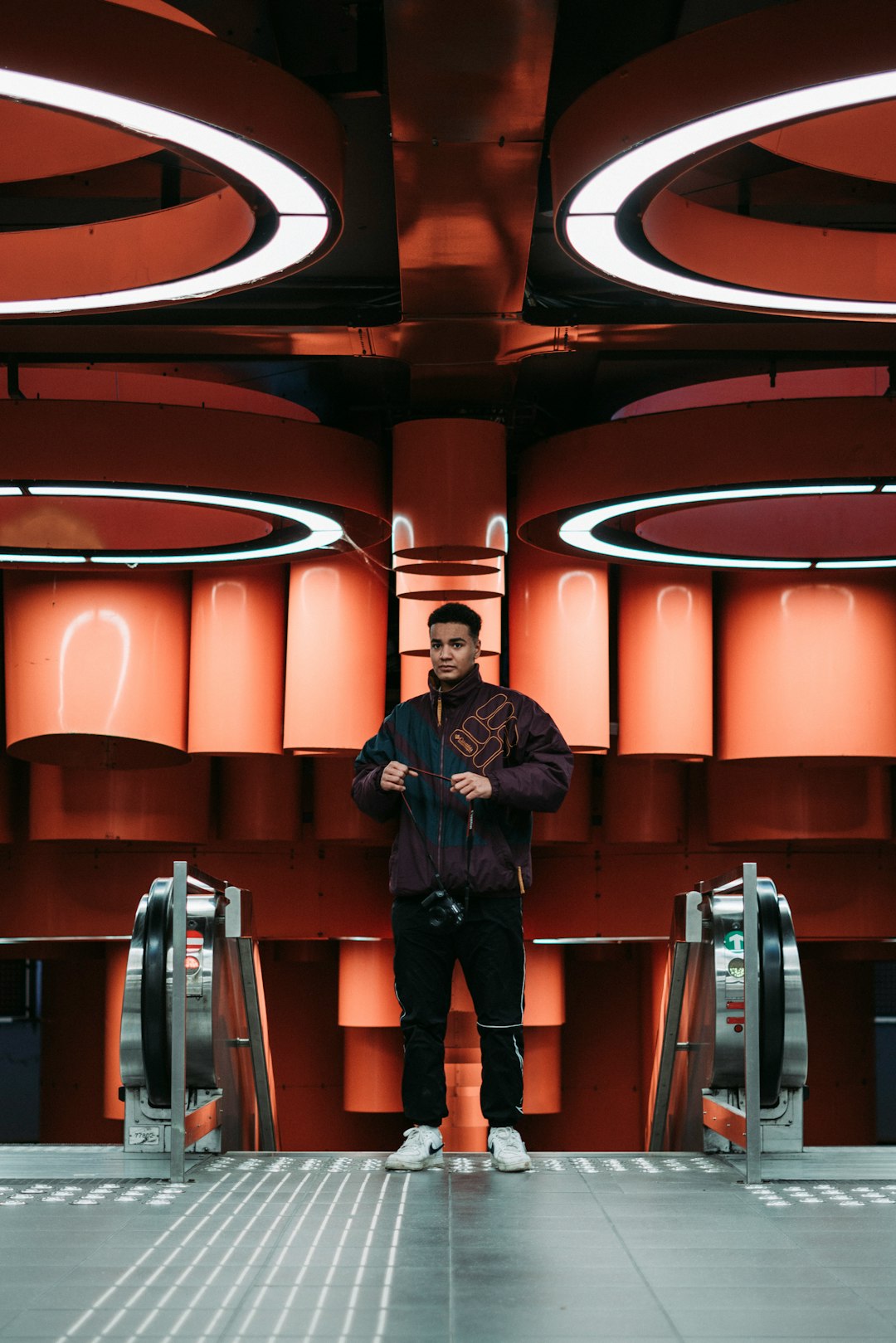 man in black jacket standing on escalator