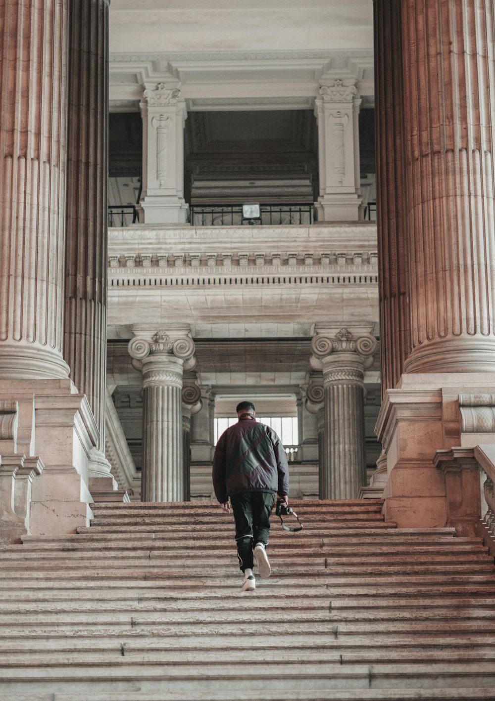woman in black jacket walking on brown concrete stairs