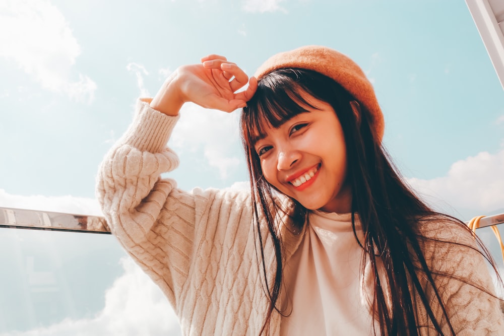 woman in white long sleeve shirt and orange knit cap