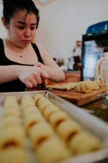 woman in black and white shirt slicing bread