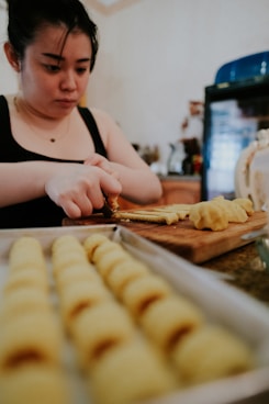 woman in black and white shirt slicing bread