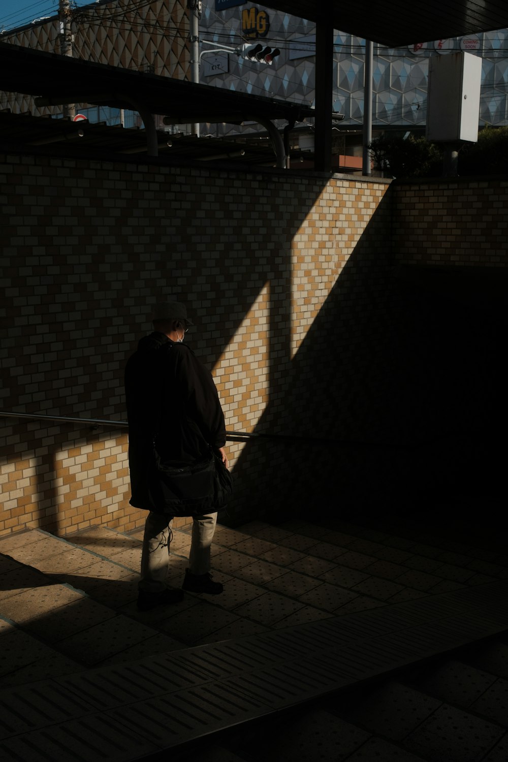 man in black jacket standing on gray brick floor during night time