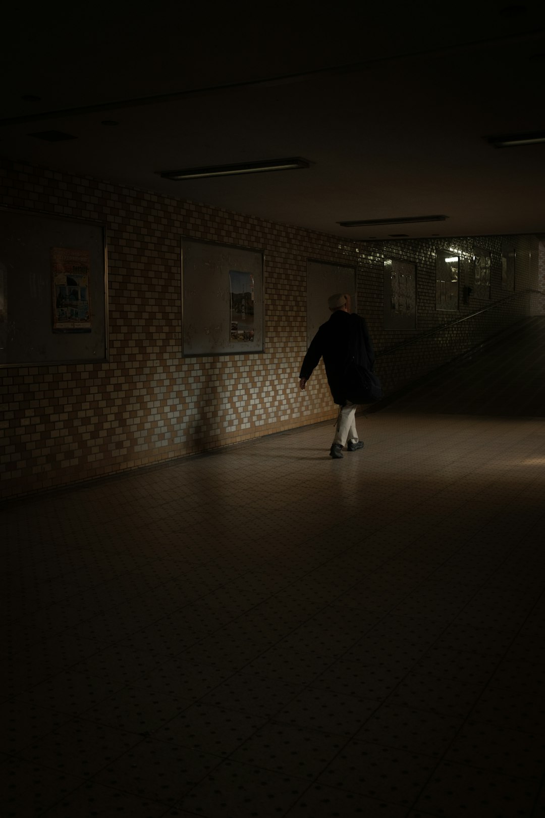 woman in black coat walking on hallway