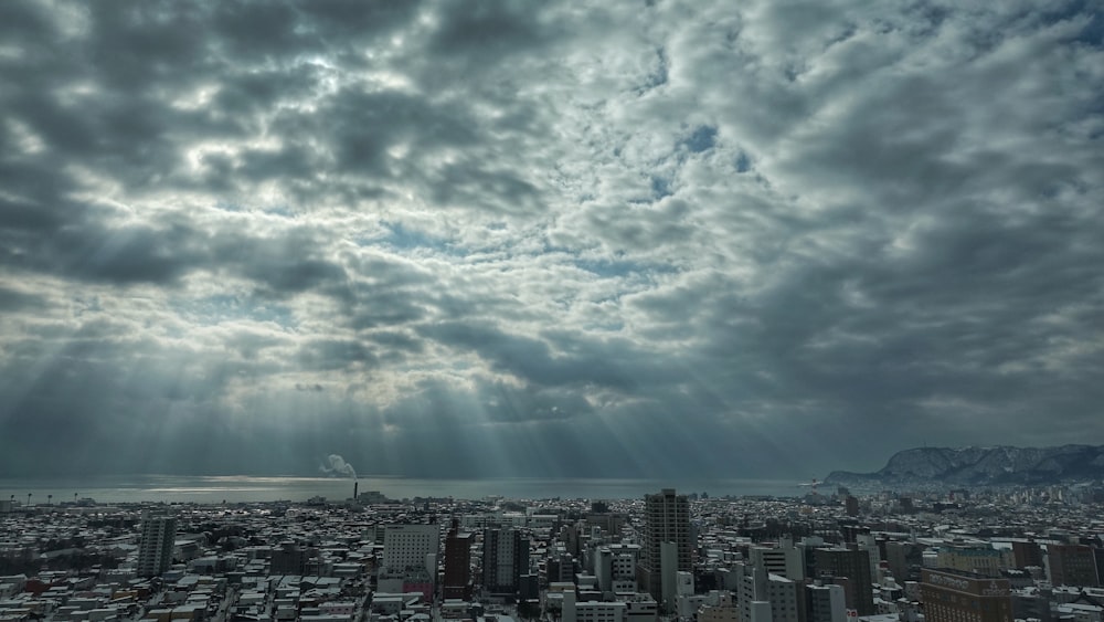 city buildings under white clouds and blue sky during daytime