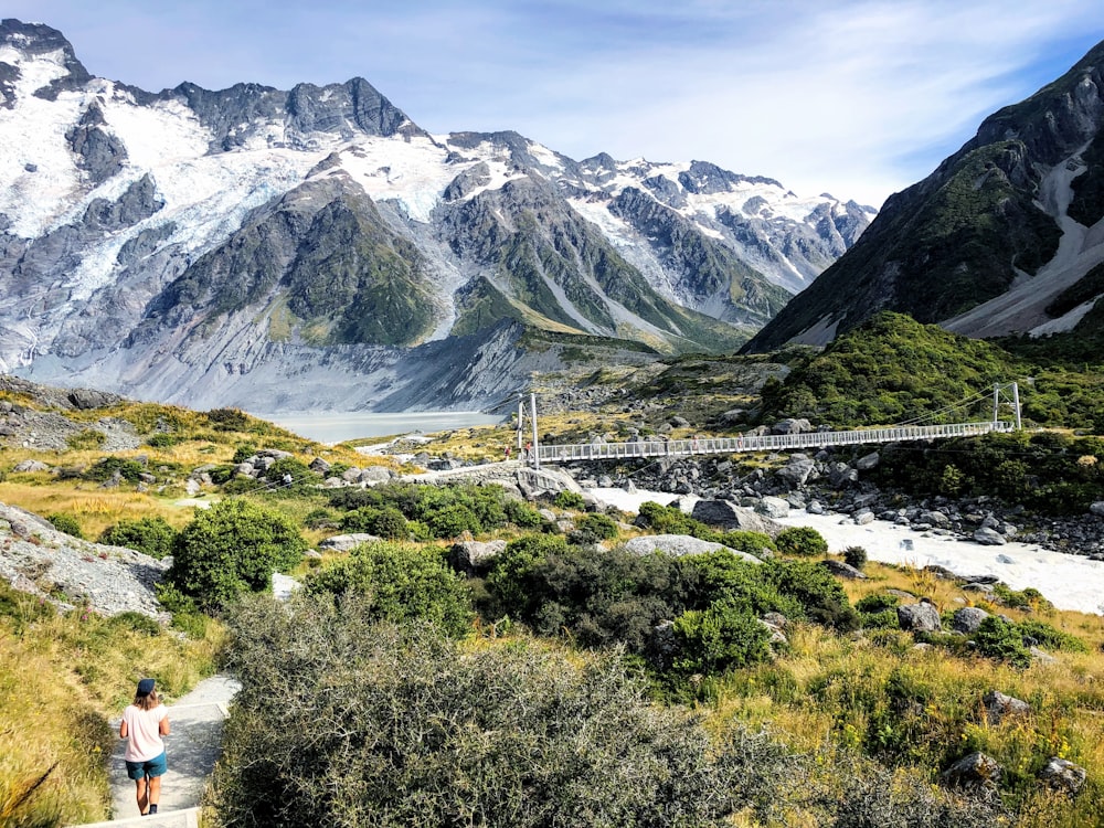 person sitting on grass field near mountain during daytime