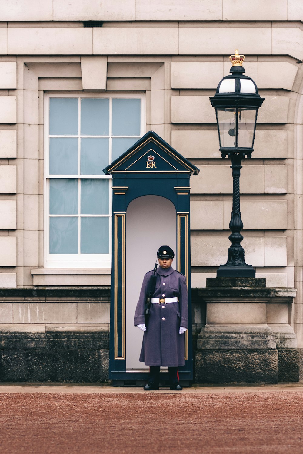 woman in blue long sleeve dress standing in front of black post lamp