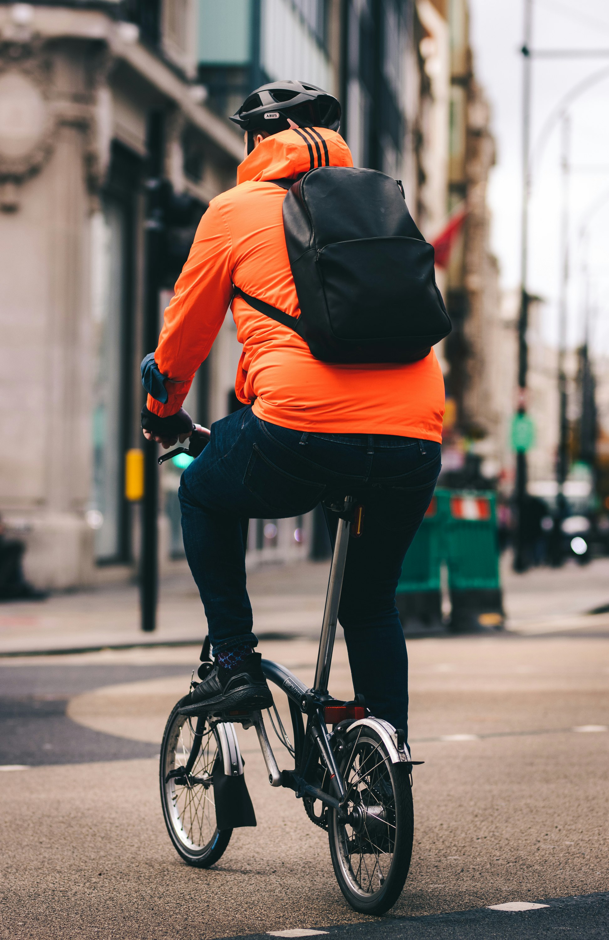 A lone cyclist on their way to work through the city of London down Regents streets