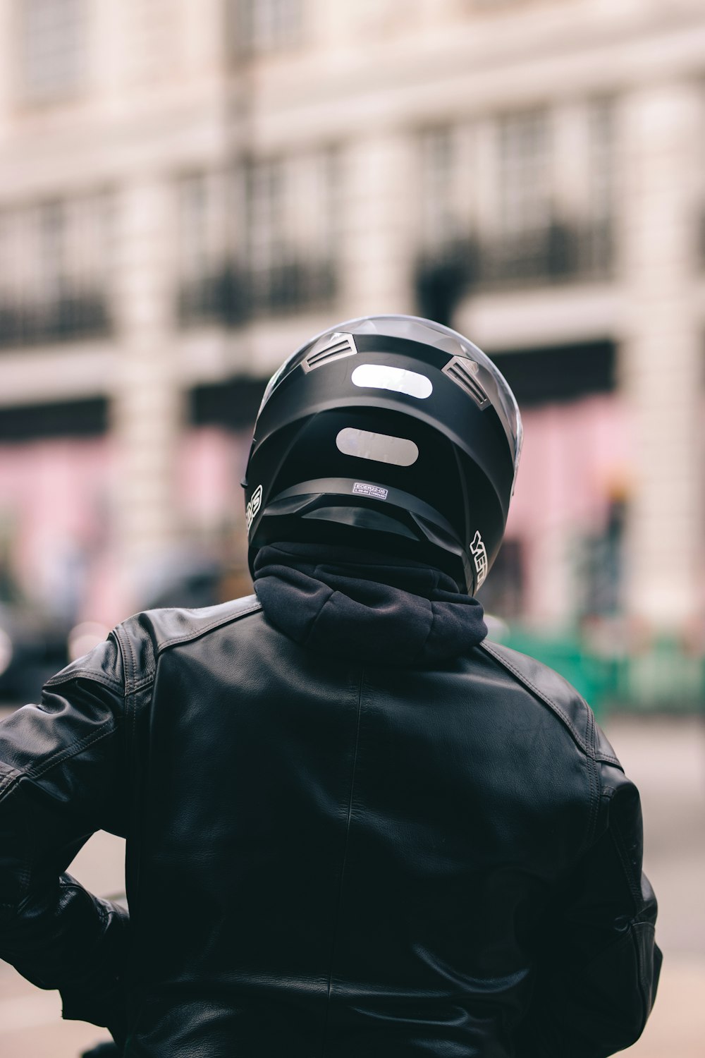 person in black leather jacket wearing black and white helmet