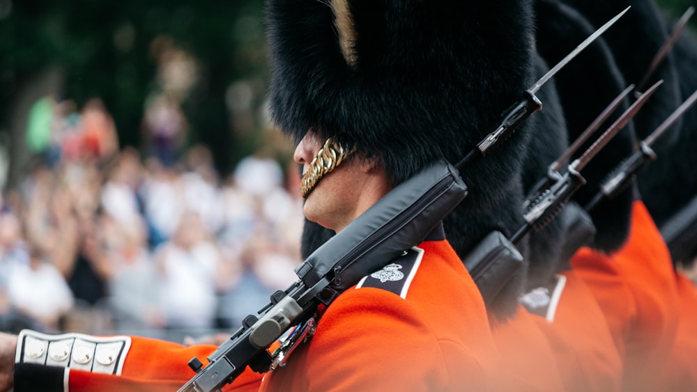 man in red and black coat holding black rifle