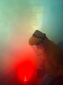 a man in a yellow suit is working on a red object