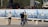 Several people are in an outdoor area near a construction site. One person in a striped sweater poses for a photograph while another holds a camera. Behind them are banners displaying images and text related to 'Estacionamiento Plaza de la República Siglo XXI'. Construction materials and equipment are visible in the background.