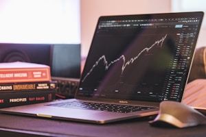 A neat stack of financial books and a tablet displaying market trends