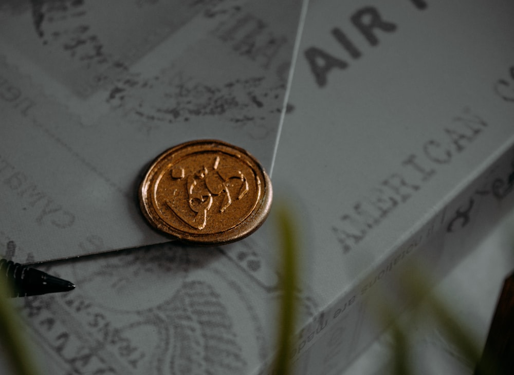 gold round coin on white paper