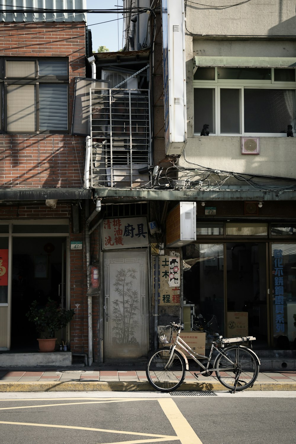 white bicycle parked beside brown concrete building during daytime