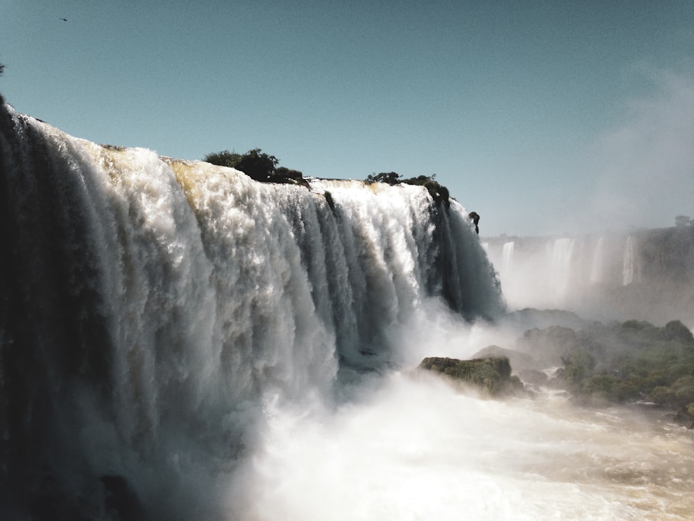 waterfalls under blue sky during daytime