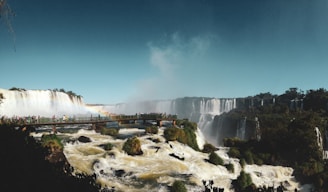 white and brown concrete building near waterfalls under blue sky during daytime