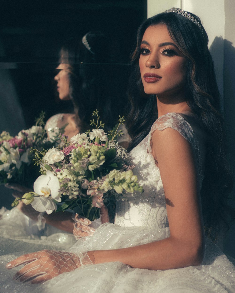 woman in white sleeveless dress holding white flowers