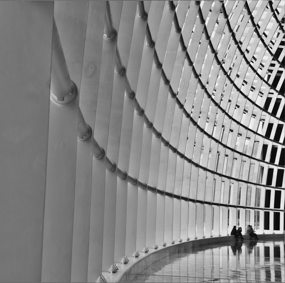 grayscale photo of people walking on spiral stairs