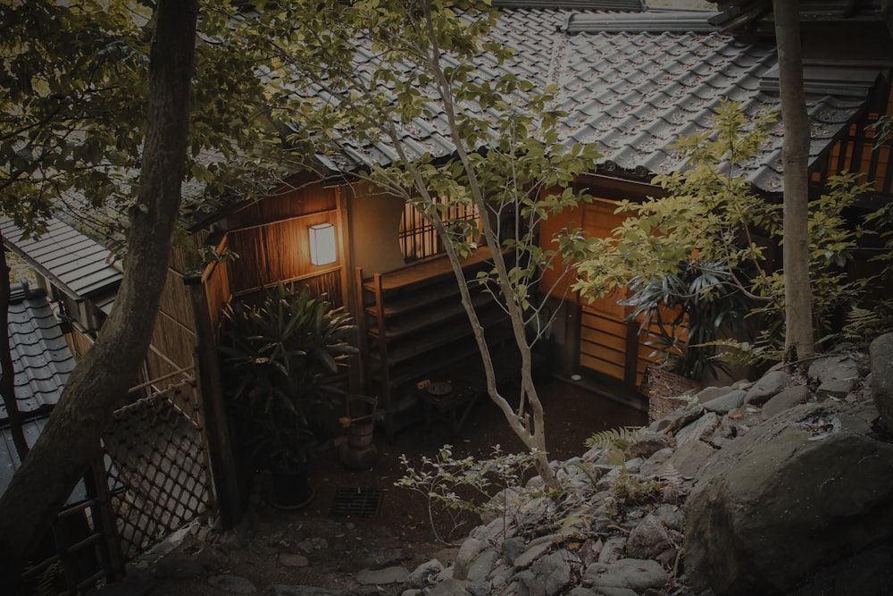 brown wooden house near green trees during daytime