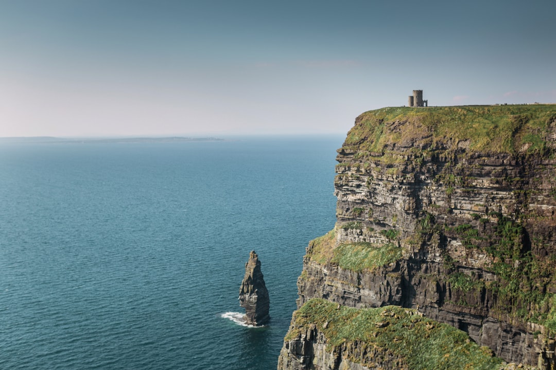 gray rock formation beside body of water during daytime