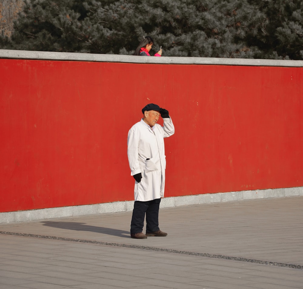 man in white long sleeve shirt and black pants standing on white floor