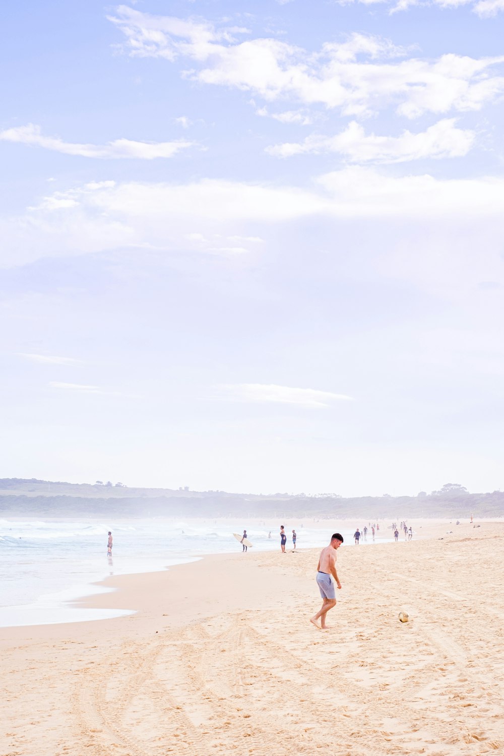 woman in white shirt walking on beach during daytime