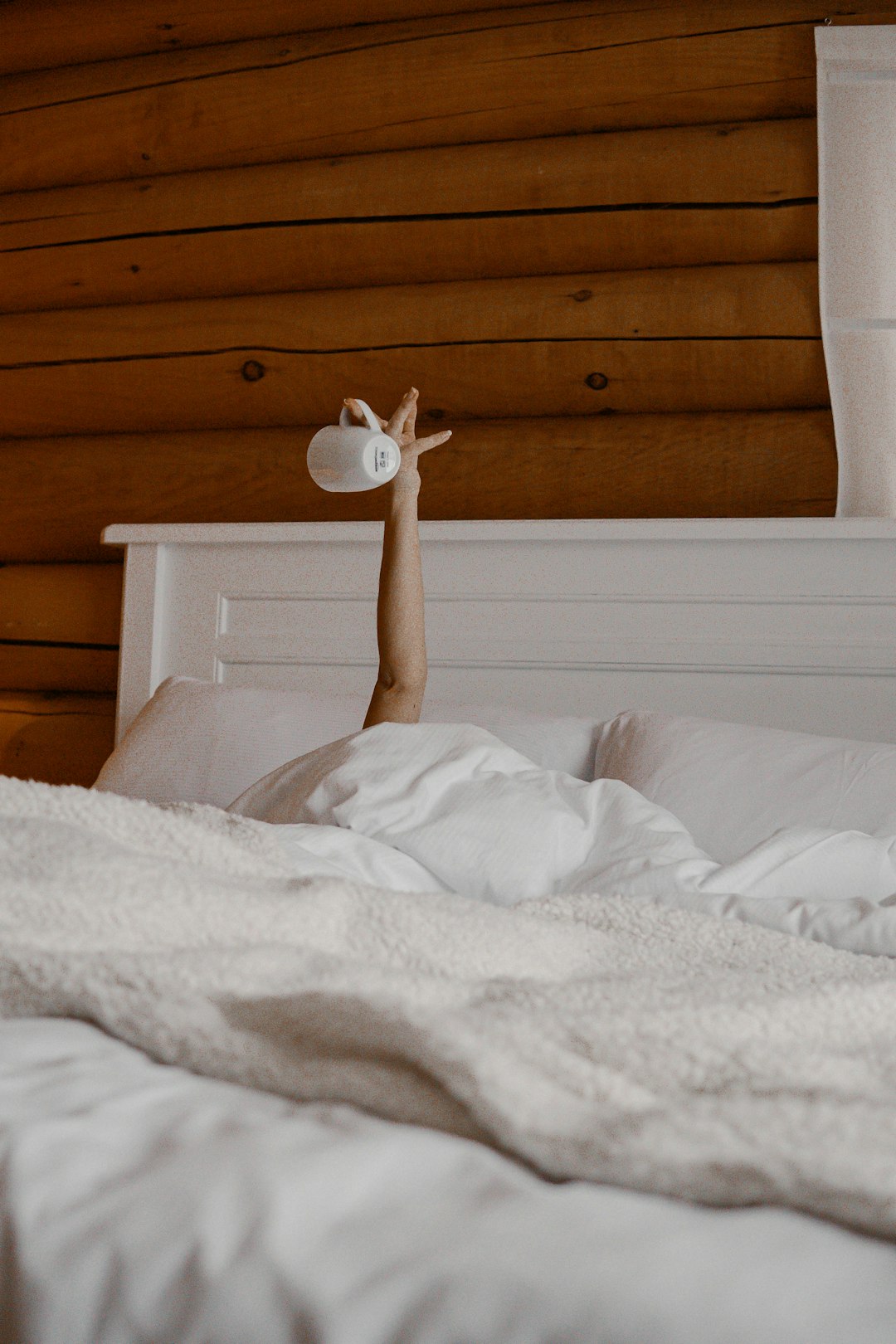 white bed linen near brown wooden headboard
