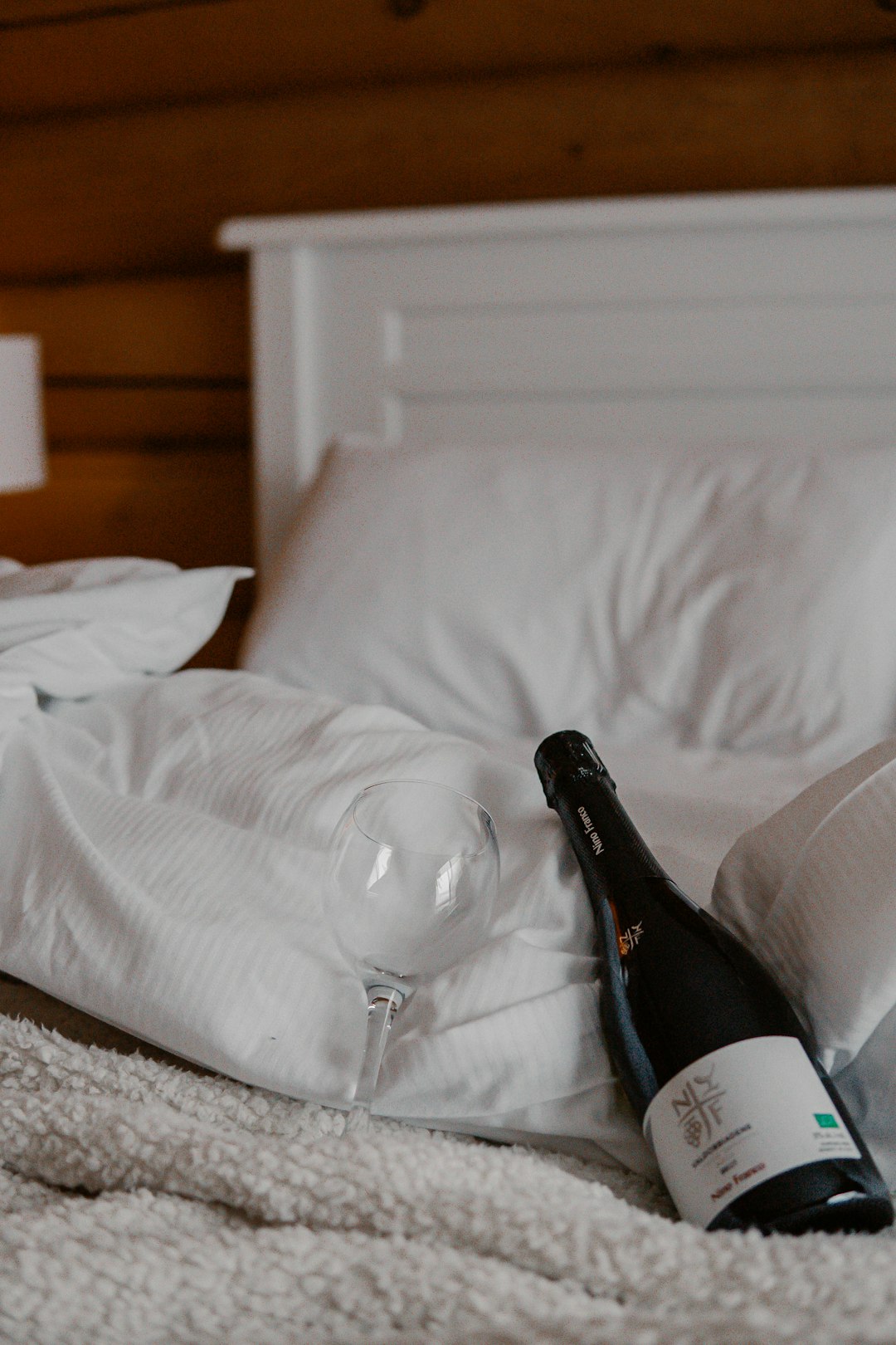 black glass bottle on white textile