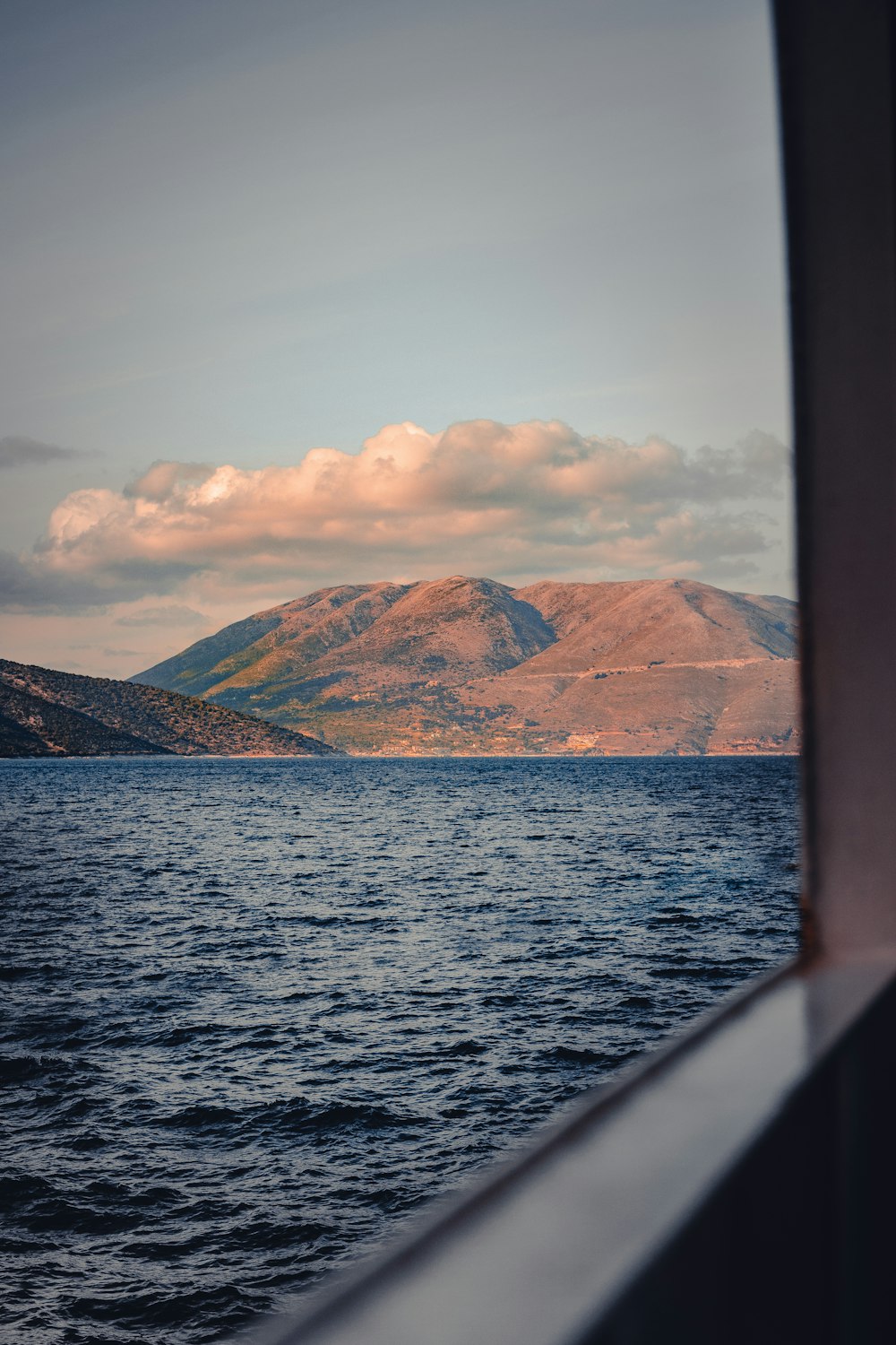 brown mountains beside body of water during daytime