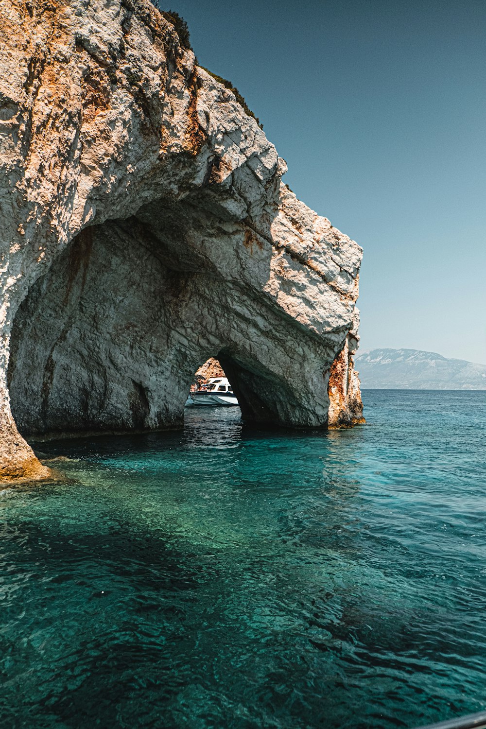 brown rock formation on blue sea under blue sky during daytime