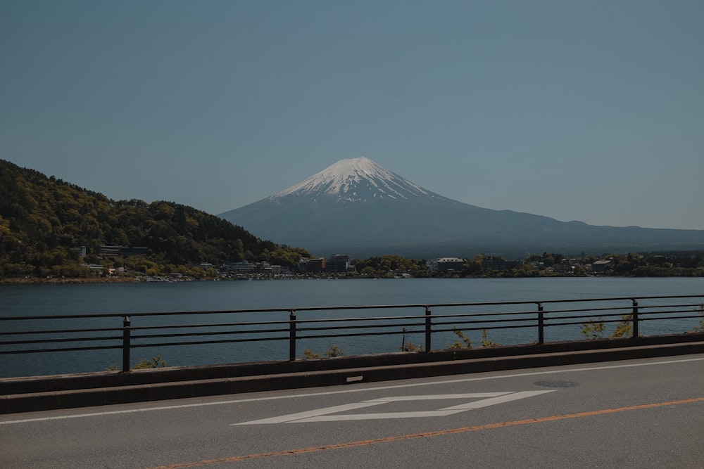 gray concrete road near body of water during daytime