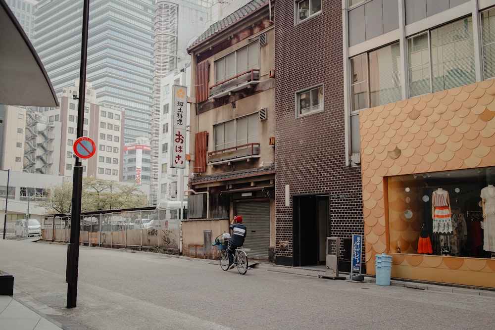 man in black jacket riding bicycle on road during daytime