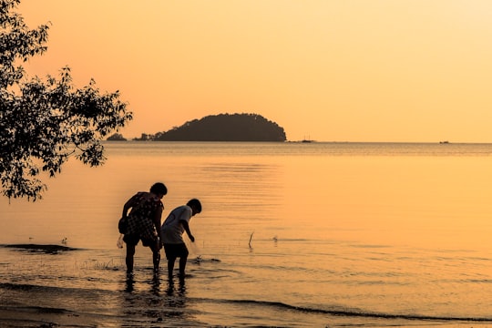 silhouette of 2 men standing on beach during sunset in Belitung Indonesia