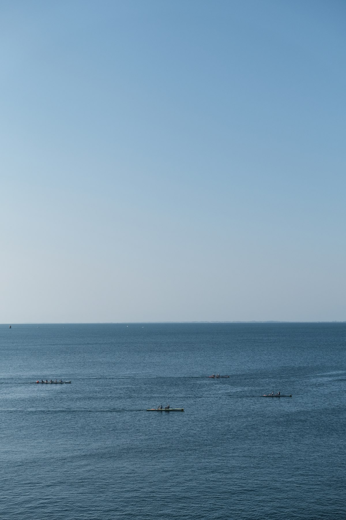 Calm water meeting a pale sky, minimalist-horizon register