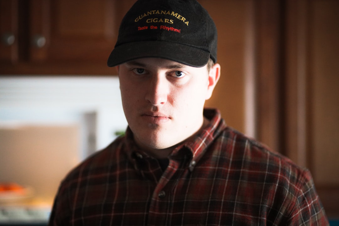 man in black and red plaid button up shirt wearing black cap