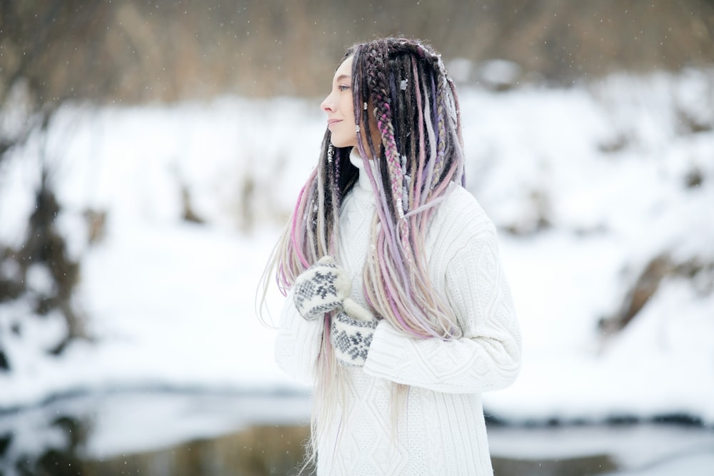 woman in white long sleeve dress standing on snow covered ground during daytime