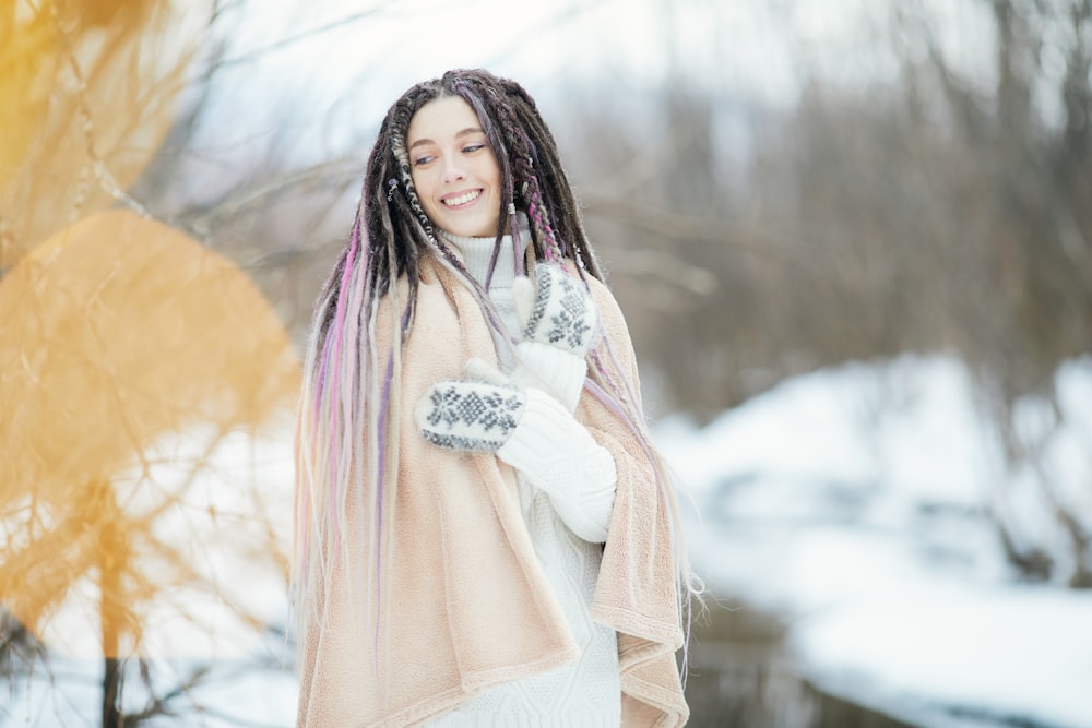 woman in pink long sleeve dress standing on snow covered ground during daytime