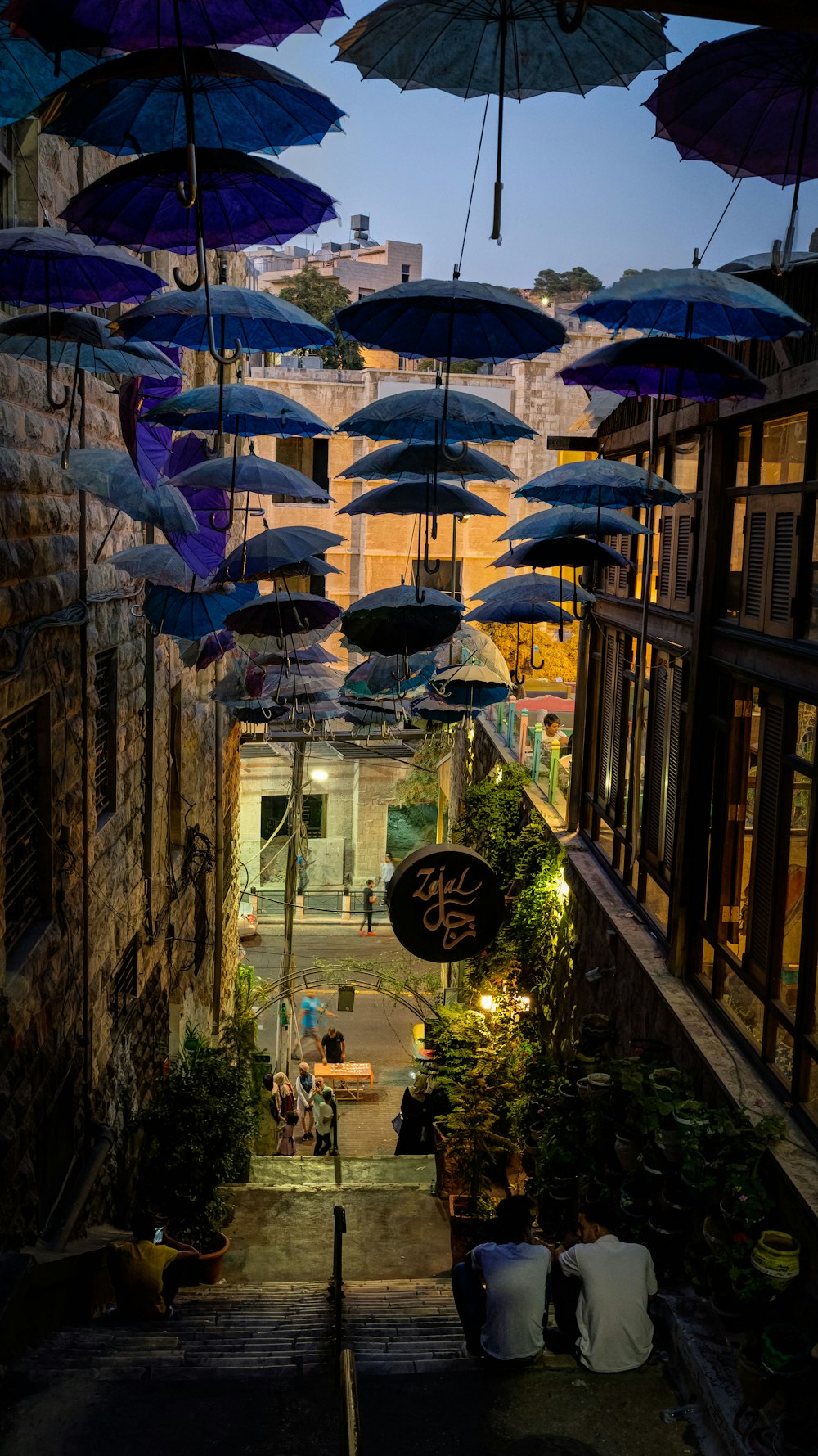 guarda-chuva azul perto do edifício de tijolo marrom
