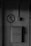 A grayscale image features an old metal mailbox mounted on a wall, with the word 'ПОЧТА' embossed on it and the number '45' displayed below. Above the mailbox, a sign depicts a cigarette with a diagonal line through it, indicating no smoking is allowed. The wall appears weathered and has electrical conduits running vertically and horizontally nearby.