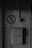 A grayscale image features an old metal mailbox mounted on a wall, with the word 'ПОЧТА' embossed on it and the number '45' displayed below. Above the mailbox, a sign depicts a cigarette with a diagonal line through it, indicating no smoking is allowed. The wall appears weathered and has electrical conduits running vertically and horizontally nearby.