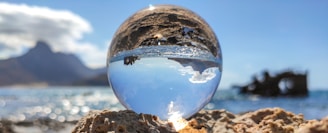 clear glass ball on brown sand during daytime