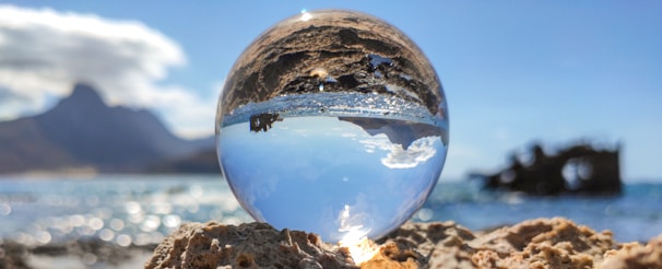 clear glass ball on brown sand during daytime