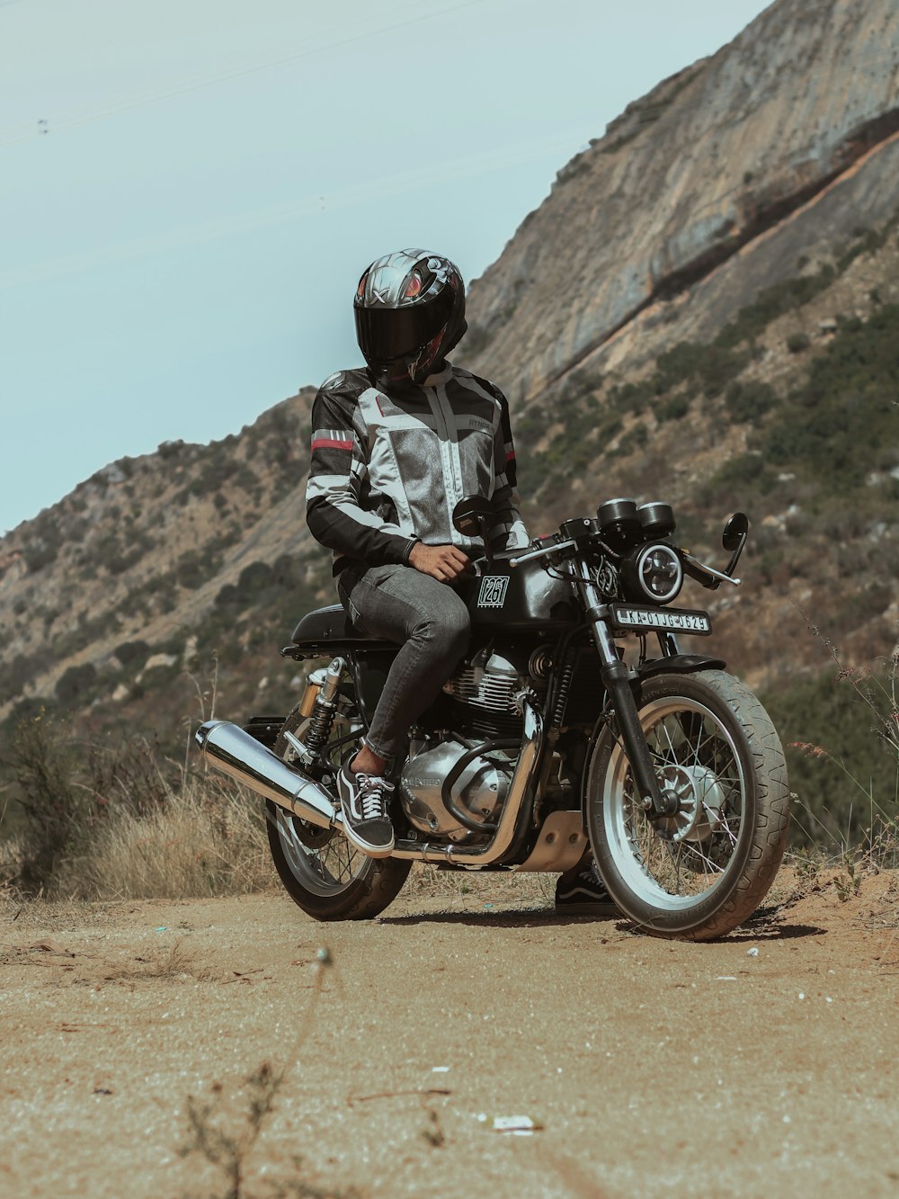 man in black jacket riding motorcycle on brown field during daytime