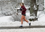 Person jogging outdoors wearing waterproof Bluetooth earphones.