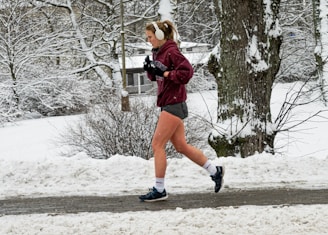 Person jogging outdoors wearing in-ear wireless headphones.
