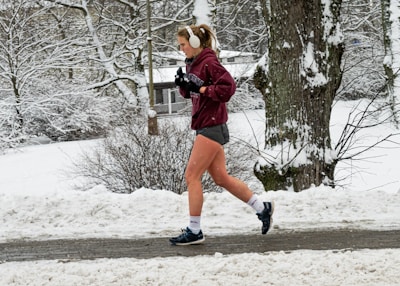 Person jogging outdoors wearing in-ear wireless headphones.